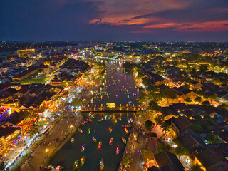 Aerial view of Hoi An old town or Hoian ancient town in sunset. Royalty high-quality free stock image top view of Hoai river and boat night traffic. One of the most popular touristic destinations © Nhut