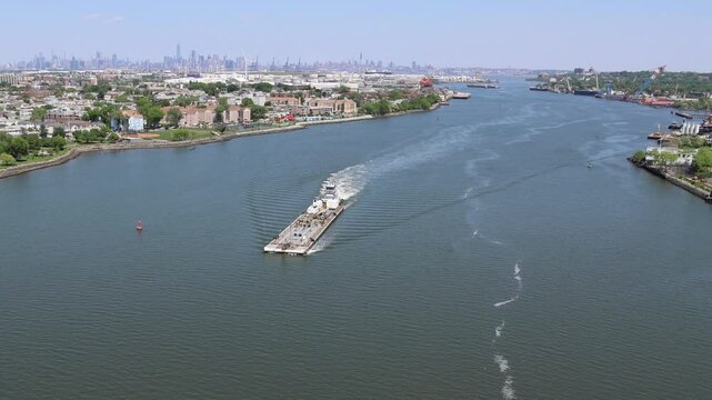 flat top barge floating down new york harbor near bayonne new jersey and staten island new york (sailing ship)