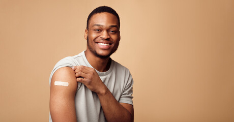 Covid-19 Vaccination. Portrait Of Happy Vaccinated African Man Showing His Arm After Coronavirus...