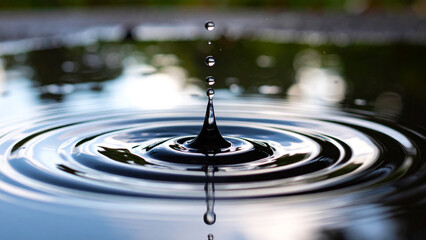 Close-Up Minimalist Shot of a Single Raindrop Creating a Tiny Ripple on Water Surface – Serene Moment in Nature