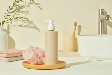 Minimal soap bottle on round tray with bath pouf and towel in warm beige bathroom. Bright foreground space perfect for label design, mockup, or promotional overlay content.