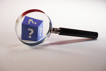 magnifying glass on white background and cubes with question mark, information search