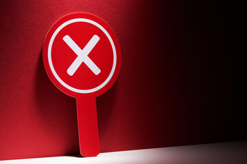 Red round placard with cross sign means rejection. placard with handle to hold