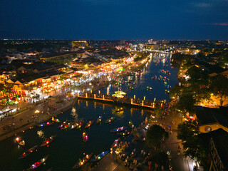 Drone footage capturing the Hoi An Lantern Festival at night, with floating lanterns, boats, and tourists along the river. Ideal for cultural, travel, and festive content