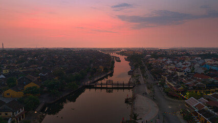 Aerial view of Hoi An old town or Hoian ancient town in sunrise. Royalty high-quality free stock top view of Hoai river and city in the morning. One of the most popular touristic destinations © Nhut