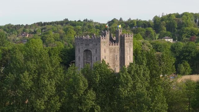 A scenic aerial view of the Bunratty Castle, surrounded by trees and hills in County Clare