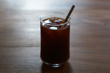 Close up glass of iced black Americano coffee with stainless steel straw