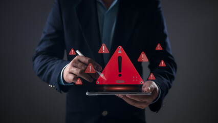 Cybersecurity threats, data breaches, system errors, and critical digital alerts. A person holding a tablet with a prominent red warning triangle and multiple smaller exclamation mark icons.