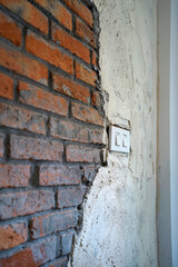 Close up plastic indoor switch panel on red brick wall