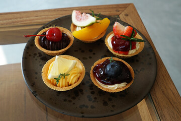 Close up dish of assorted berries, chocolate and lemon tartlets