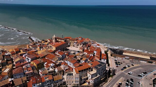 Aerial circle around Termoli cathedral and fortress. Italian coastal old town village, colorful rooftops