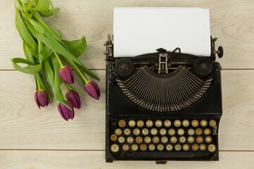 Typewriter and flowers on table