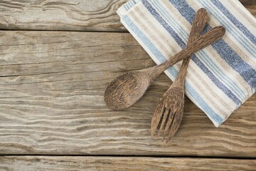 Wooden spoon and fork with napkin on table
