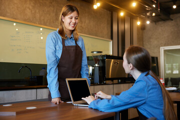 young barista meeting and talking about work in the cafe