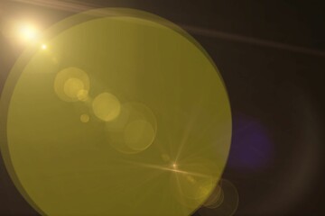 Image of light with lens flare and bokeh yellow light spots on dark background, with copy space