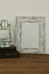 Photo frame and lantern on table