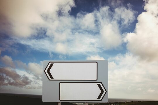 Fototapeta Blank sign posts over cloudy sky