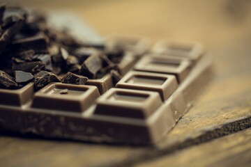 Milk chocolate bar with dark chocolate shards is resting in digital illustration on wooden tabletop