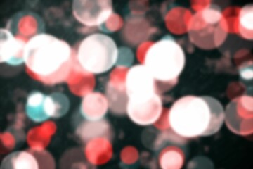 Out-of-focus light circles overlapping in red white teal against dark backdrop, forming bokeh glow