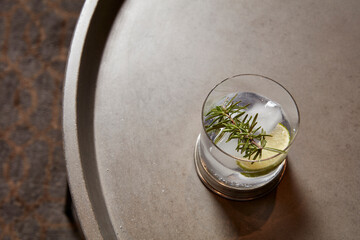 Gin and Tonic with Lime and Rosemary on Stone Table
