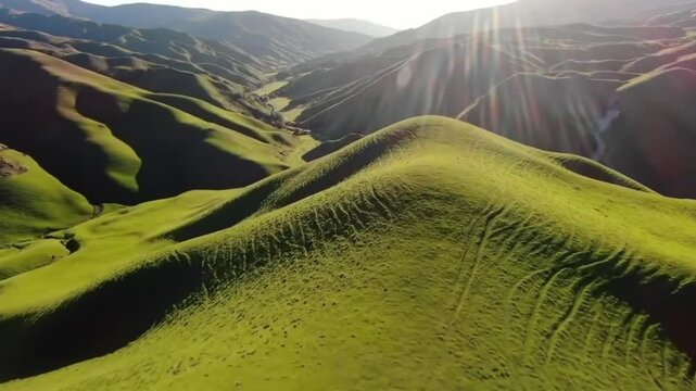 A series of mountain ridges glowing in golden light with shadows and sun rays adding dramatic depth.