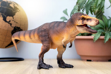 T-rex Dinosaur toy. Tyrannosaurus rex with Dorstenia Plant in plastic pot simulate and mini globe...