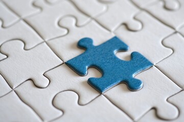 Fototapeta premium A single blue puzzle piece next to a missing spot on a white puzzle layout, top view