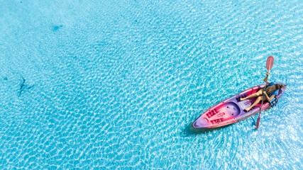 Fototapeta premium Aerial view of a kayak in the blue sea .Woman kayaking She does water sports activities.