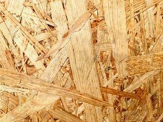 Oriented strand board (OSB) surface showing detailed wooden chip pattern, perfect for texture references, construction material stock, or architectural backgrounds