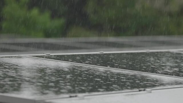 強い雨に打たれるソーラーパネル