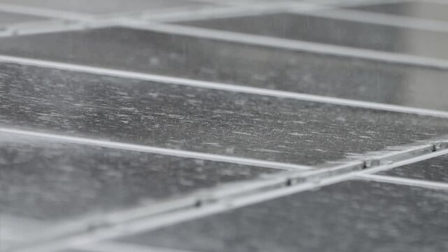 強い雨に打たれるソーラーパネル