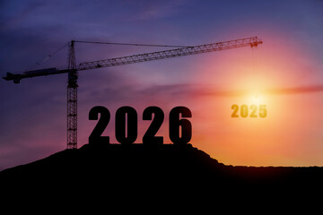 Silhouette crane lifting 2025 to reveal 2026 at sunset, concept of transition, progress, and new year development