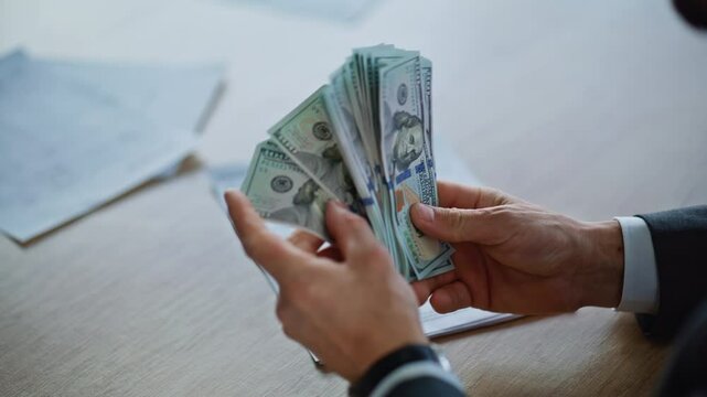 Closeup hands counting money in luxury office. Businessman delivering dollars