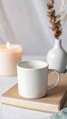 White Mug on Book with Candle and Vase