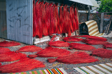 Dyed red reeds are dried at village handicraft factory for the production of traditional Vietnamese...