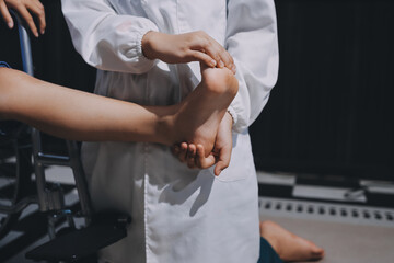 Physiotherapist checking knee of female patient stock