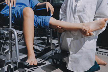 Physiotherapist checking knee of female patient stock