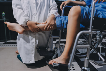 Physiotherapist checking knee of female patient stock