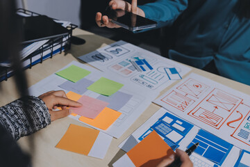 Group of young application developers analyzing uxui mobile app templates during a working meeting