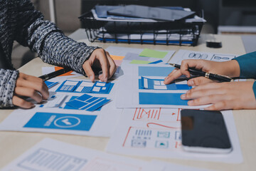 Group of young application developers analyzing uxui mobile app templates during a working meeting