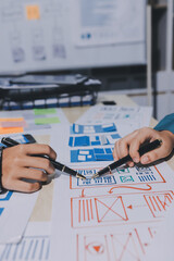 Group of young application developers analyzing uxui mobile app templates during a working meeting