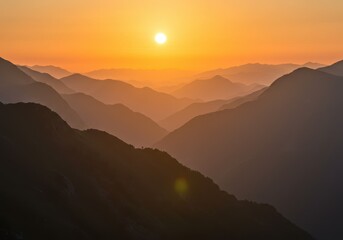 Obraz premium A breathtaking sunset illuminates layers of hazy mountains creating a stunning landscape