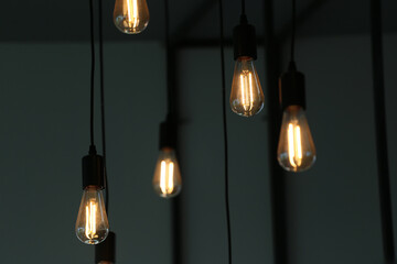 Aesthetic Close-Up View of Elegant Hanging Light Bulbs Creating a Warm and Inviting Atmosphere in...