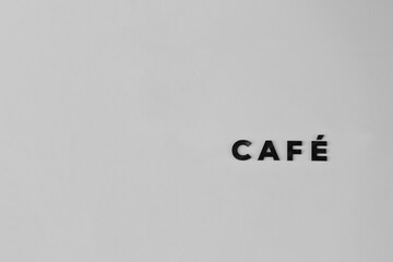 Minimalist Black and White Signage for Café Featuring Textural Contrast Against a Light Background, Emphasizing Modern Aesthetic and Simple Design Elements