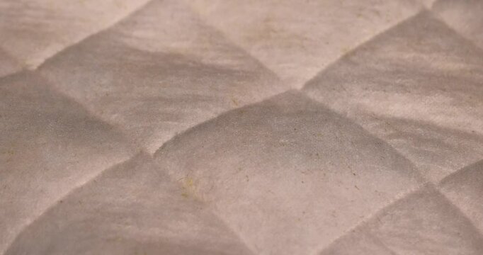 old cotton mattress, part of the fabric from which the mattress is sewn after prolonged use, close up