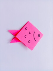 Pink fish origami isolated on white background.