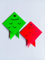 Green and red fish origami isolated on white background.