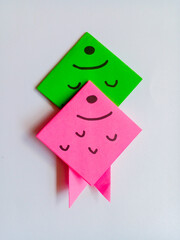 Green and pink fish origami isolated on white background.
