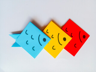 Blue, yellow and red fish origami isolated on white background.