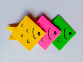 Yellow, pink and green fish origami isolated on white background.